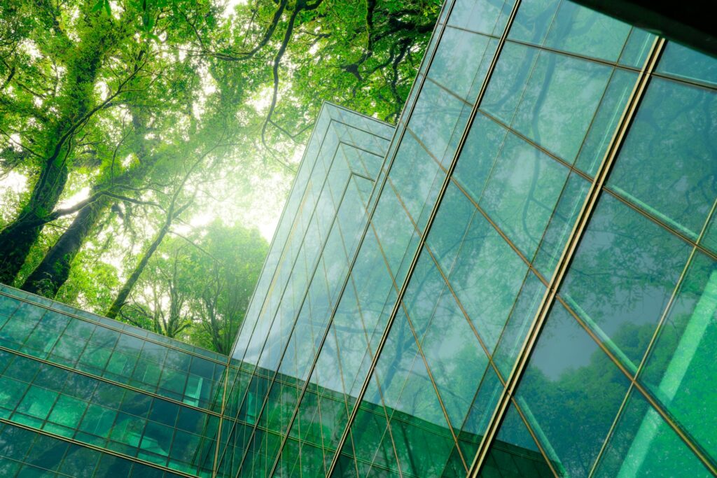 Eco-friendly building in modern city. Sustainable glass office building with trees for reducing CO2.