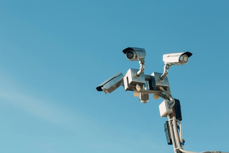 Surveillance camera on blue sky background